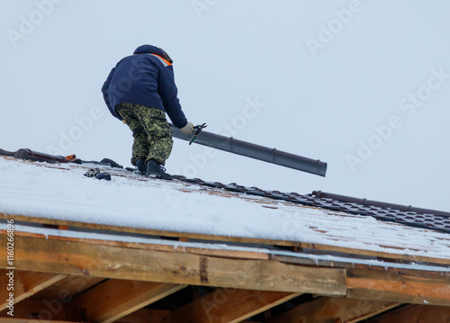 Wallpaper Mural A man in a blue jacket is working on a roof Torontodigital.ca