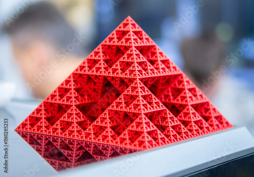 Art object printed on 3D printer from red melted plastic close-up. Model of pyramid created on 3D printer from plastic. 3D Printing technology. Additive progressive technology. New modern technologies photo