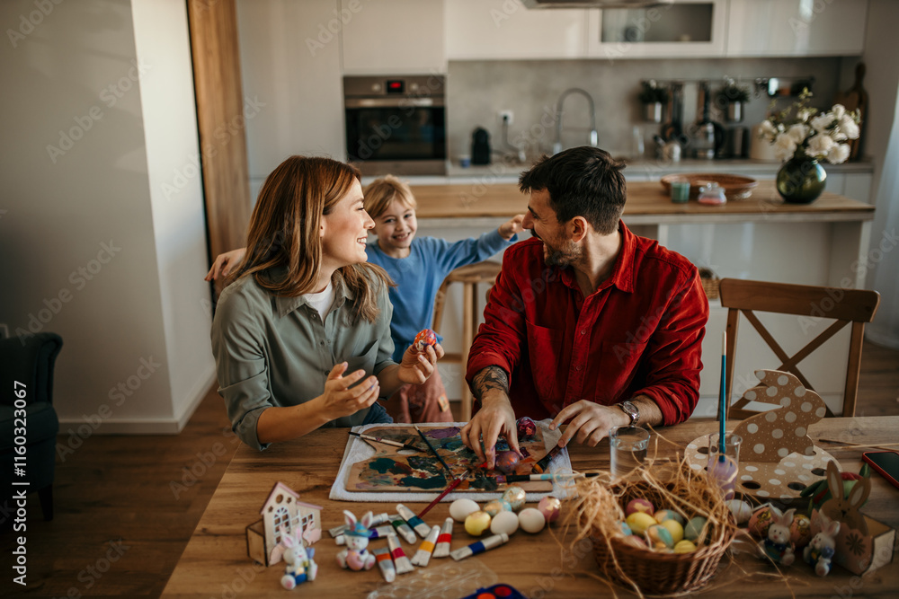 Fototapeta premium Family painting Easter eggs while surrounded by festive decor.