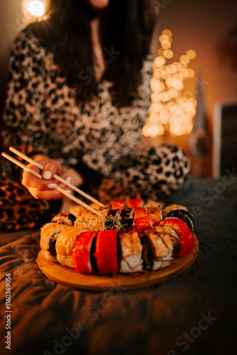 Enjoying fresh sushi in pajamas while relaxing in a cozy, warmly lit bedroom