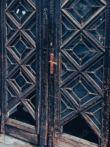 Double antique wooden doors with partially knocked out glass inserts