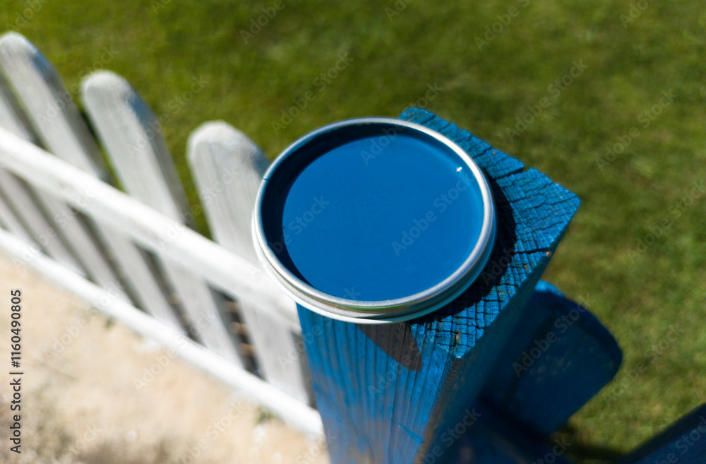 Blue paint can lid resting over fence pole