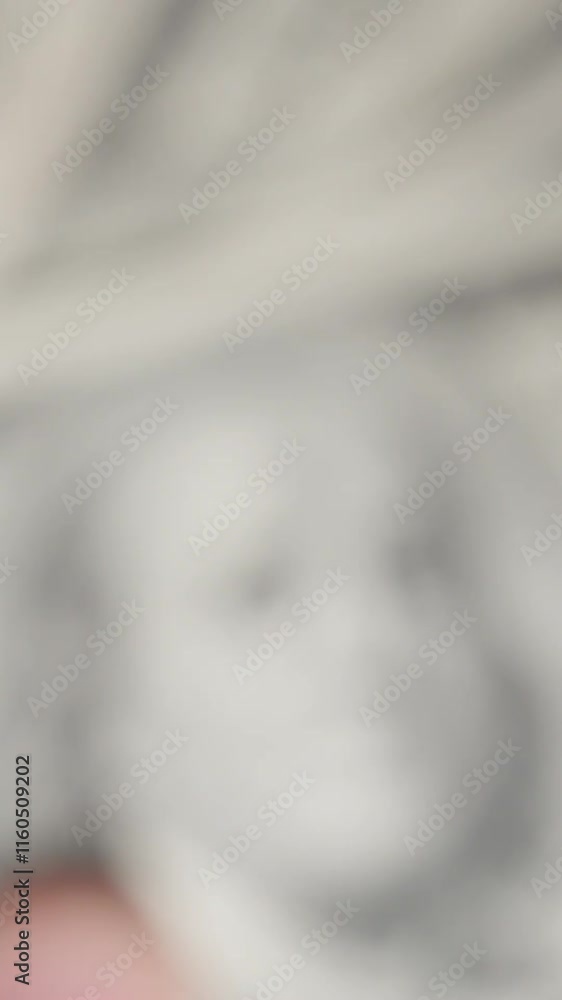 Vertical video. A hand lifting a stack of old-style hundred-dollar bills over a backdrop of modern ones, gradually filling and closing the frame, emphasizing contrast and value.