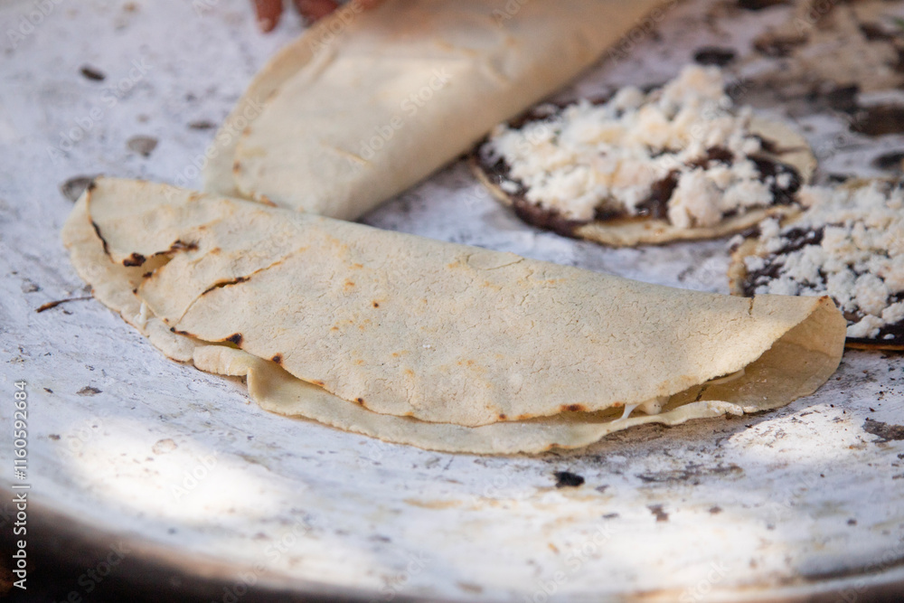 Mexican quesadillas with tomato, squash blossoms and hoja santa (piper auritum) cooked on a traditional griddle over fire.