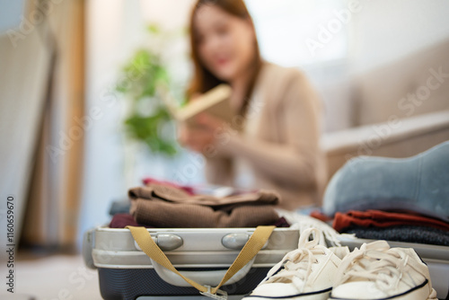 Travel preparation. Cheerful young asian woman packing suitcase, getting ready for vacation at home, copy space. Female going on tourist trip, happy about abroad adventure. photo