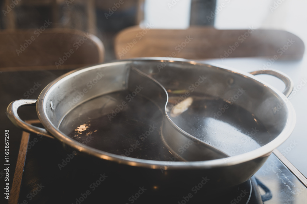 Combo pot for two flavors of hot pot soup base with lots of steam Combo pot for two flavors of hot pot soup base with lots of steam