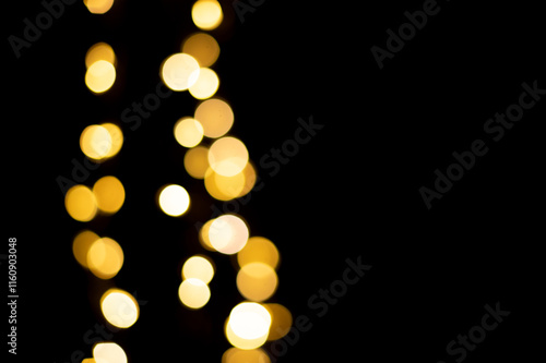 Golden blurred bokeh lights on black background. Christmas lights overlay.