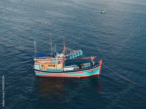 Aerial view, top view of fishing boat anchored on the sea. Royalty high quality free stock of Wooden fishing boats are moored with ropes to the pier on Mui Ne, Binh Thuan, Vietnam photo