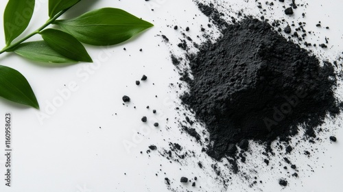 Charcoal, powdered charcoal and leaves on white background