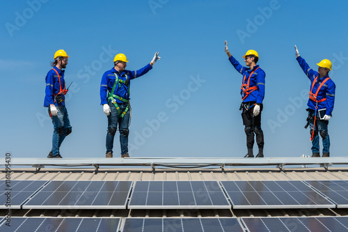 Group of solar technician teammates working together on solar roof installation photo