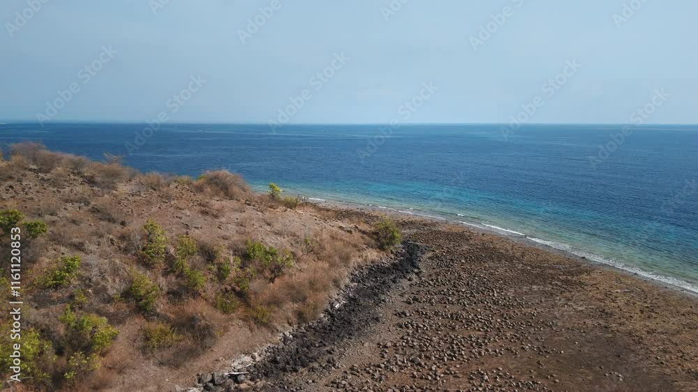 Landscape with blue ocean and scorched savanna vegetation in Pemuteran area on West Bali Landscape with blue ocean and scorched savanna vegetation in Pemuteran area on West Bali