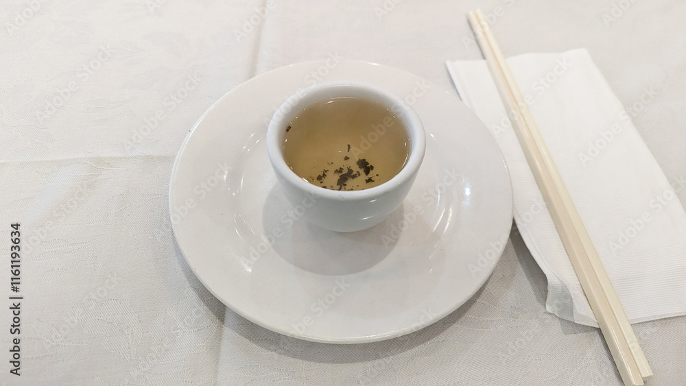 Photo of green tea place setting with chopsticks, napkin, and tableware tradition, hospitality, celebration, Chinese culture. Concept of Chinese new year, lunar year, dim sum, green tea, dining. Photo of green tea place setting with chopsticks, napkin, and tableware tradition, hospitality, celebration, Chinese culture. Concept of Chinese new year, lunar year, dim sum, green tea, dining.