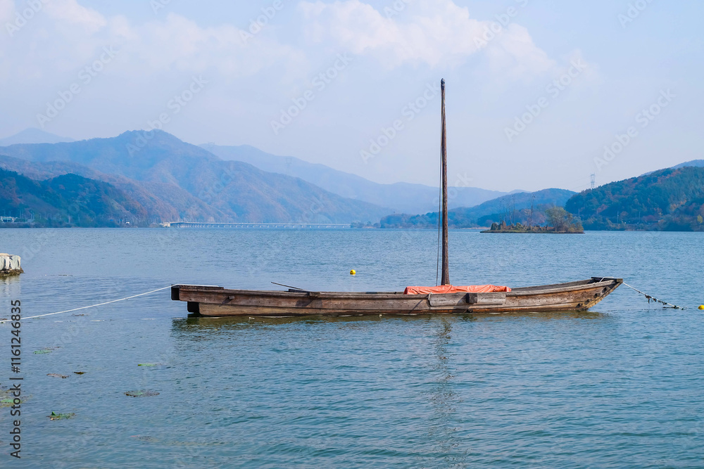 The boat is in the lake and under the blue sky The boat is in the lake and under the blue sky