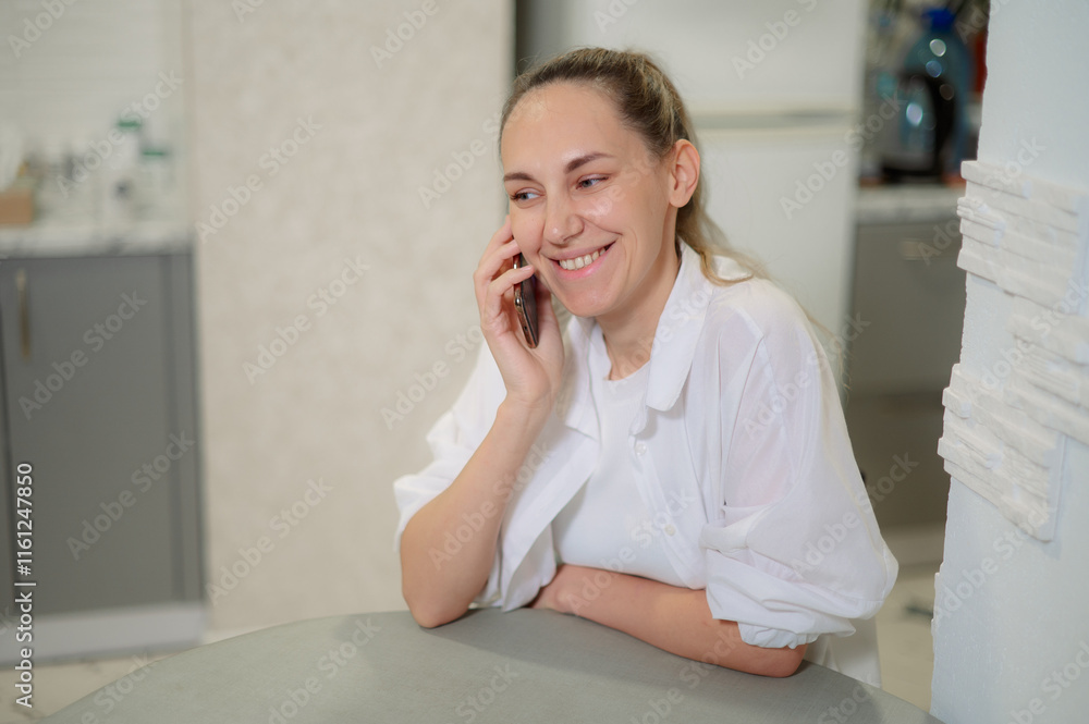 Young emotion woman 30s sitting comfortably on sofa, smiling while using her smart phone indoors during a relaxing afternoon Young emotion woman 30s sitting comfortably on sofa, smiling while using her smart phone indoors during a relaxing afternoon