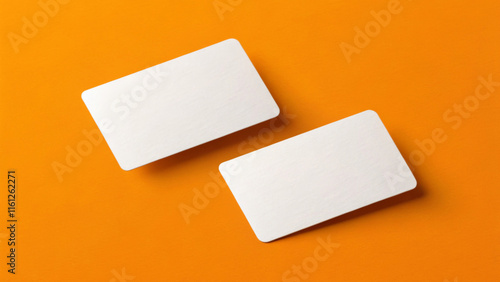 Two blank white business cards are placed on a light orange background. The cards are arranged at an angle, creating a dynamic and minimalist composition,with copy space. AI generated. photo