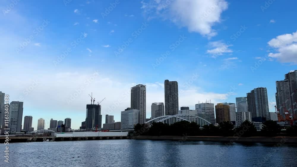 A tranquil view of Tokyo skyscrapers near Hama Rikyu Gardens with a vibrant blue sky A tranquil view of Tokyo skyscrapers near Hama Rikyu Gardens with a vibrant blue sky