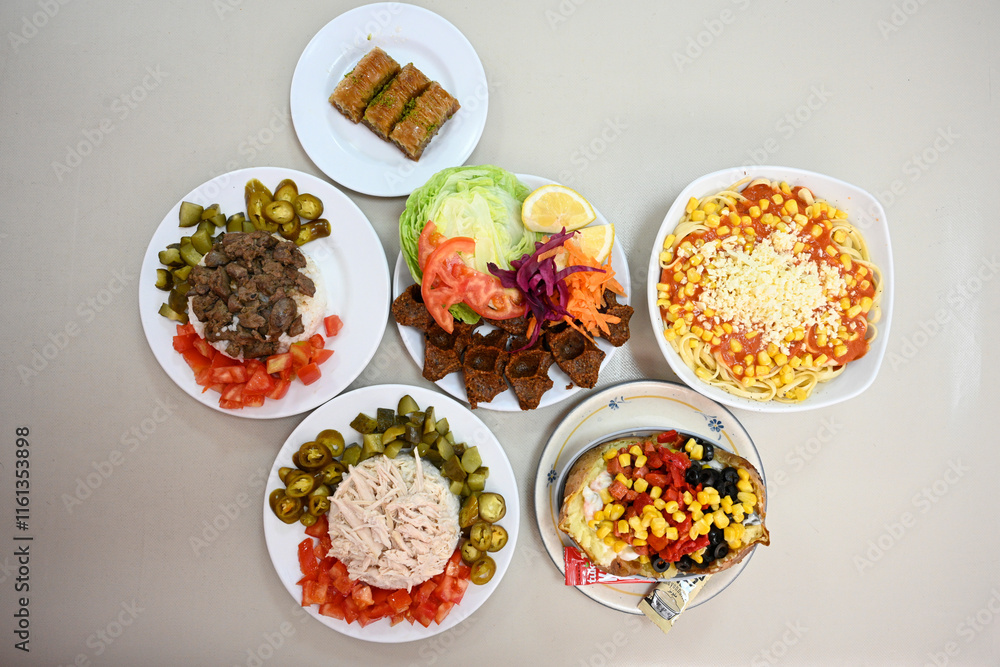Delicious meat kebab with fresh vegetable salad served with variety of Turkish dishes and appetizers. Top view of assorted Turkish food and meze, tasty and healthy Mediterranean cuisine. Delicious meat kebab with fresh vegetable salad served with variety of Turkish dishes and appetizers. Top view of assorted Turkish food and meze, tasty and healthy Mediterranean cuisine.