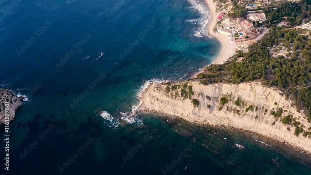Fototapeta premium Aerial view of San Martin Cape, with the islet and beach of Portichol, in the Mediterranean coast of Javea, Alicante, Spain.