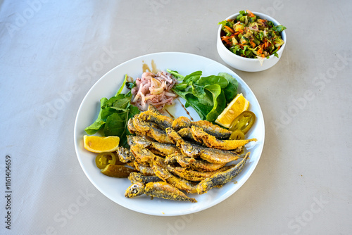 Fried Anchovies (Turkish Name: Hamsi Tava) .Hamsi, istavrit, sardalya tava. Balik kizartma. Izgara cipura levrek, palamut  yesil salata. photo