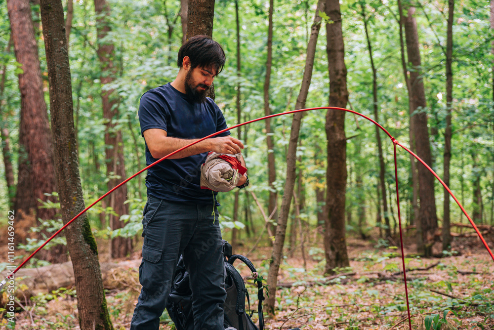a man puts up a tent in the forest a man puts up a tent in the forest