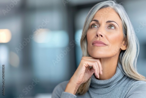 Mature caucasian woman with gray hair contemplating in a modern setting photo