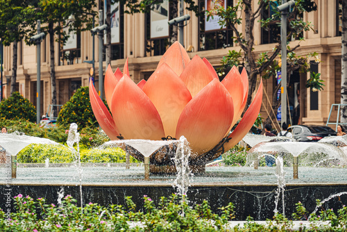 Close-up of the lotus flower and water jets at the roundabout in Nguyen Hue Street in front of the city hall in Vietnam.