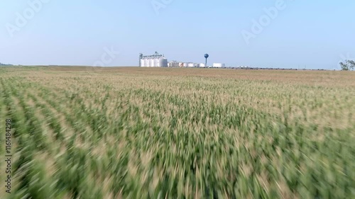 Fast moving drone shot over corn fields in South Dakota with Ethanol plant in the background.