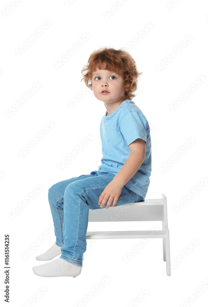 Little boy sitting on step stool against white background