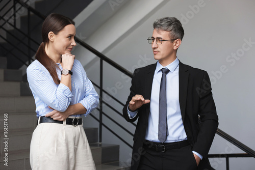 Coworkers talking while going down stairs in office