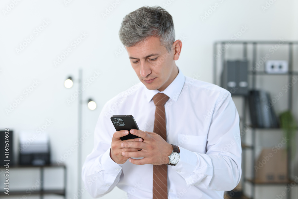 Portrait of businessman using smartphone in office Portrait of businessman using smartphone in office