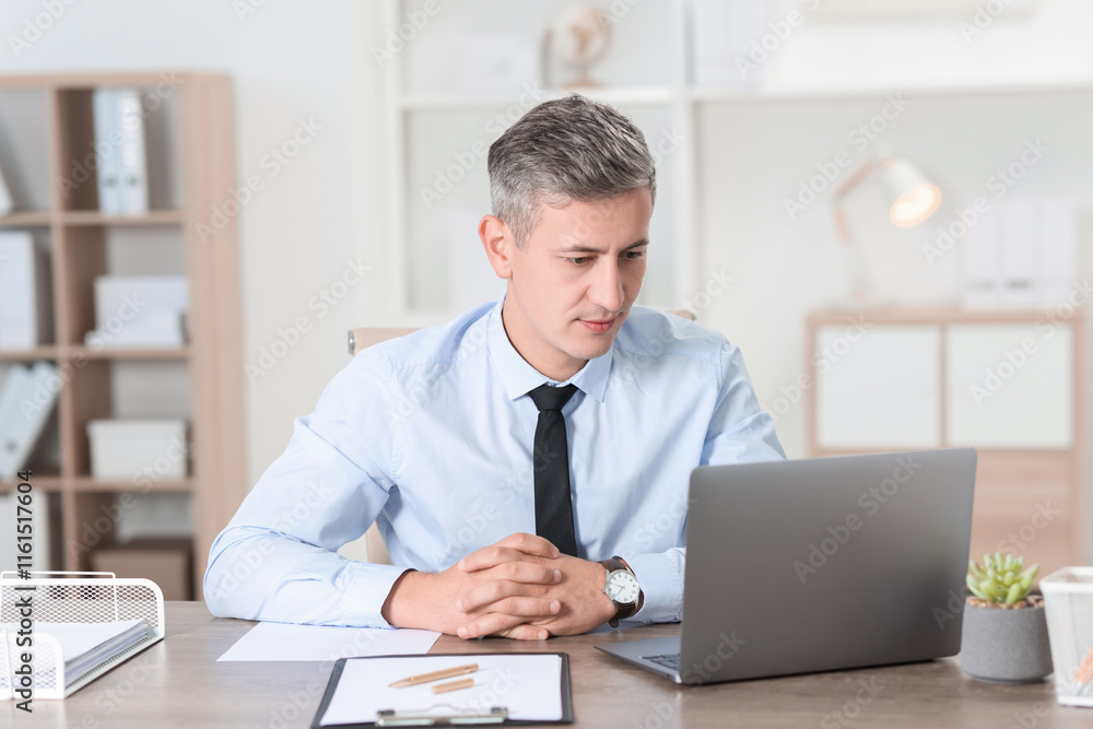 Businessman working with laptop at table in office Businessman working with laptop at table in office
