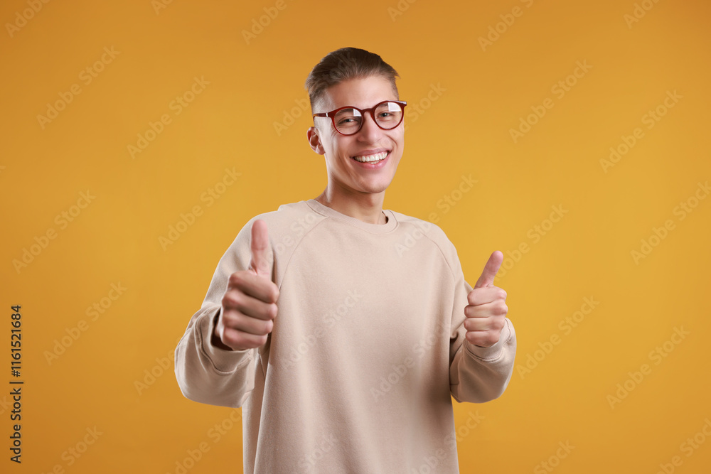 Happy man showing thumbs up on orange background. Like gesture Happy man showing thumbs up on orange background. Like gesture