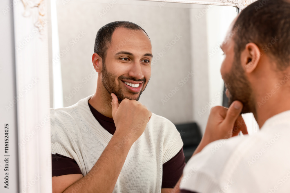 Smiling man looking at mirror at home Smiling man looking at mirror at home