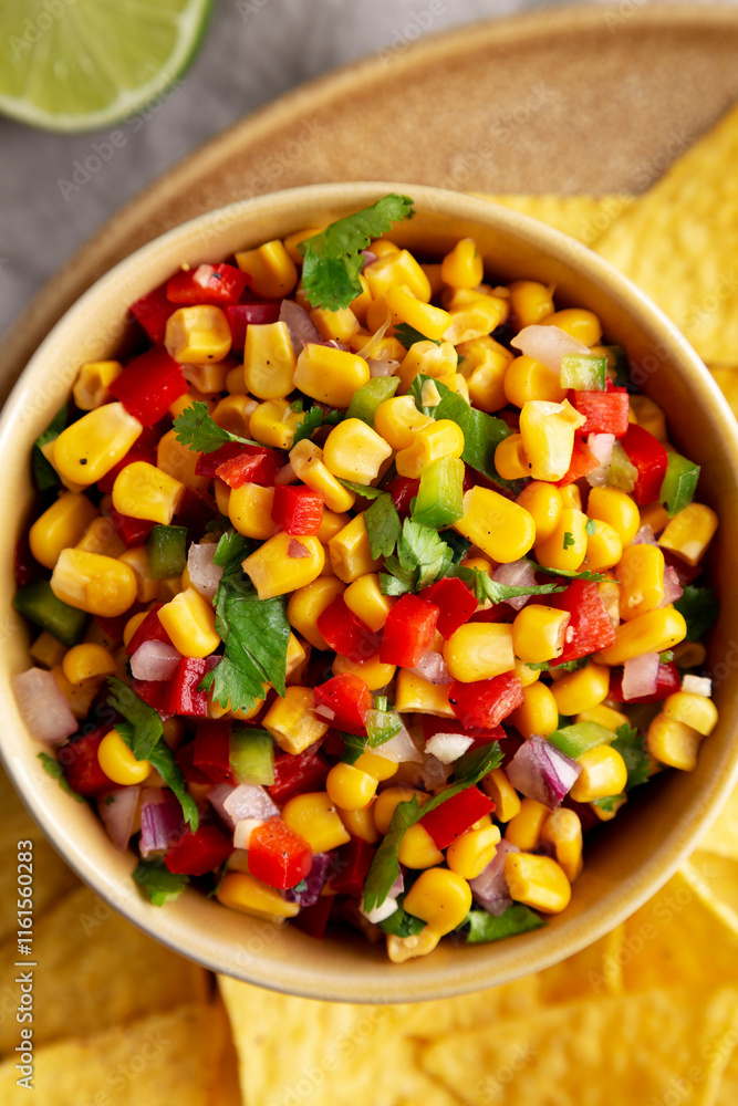 Homemade Corn Salsa with Tortilla Chips on a Plate, top view. Flat lay, overhead, from above. Homemade Corn Salsa with Tortilla Chips on a Plate, top view. Flat lay, overhead, from above.