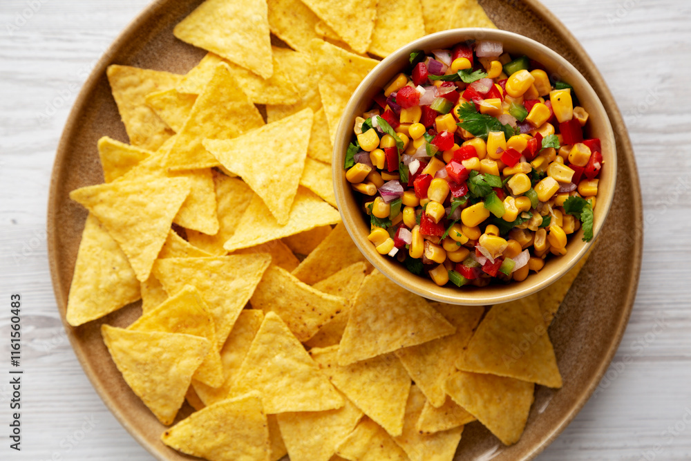 Homemade Corn Salsa with Tortilla Chips on a Plate, top view. Flat lay, overhead, from above. Homemade Corn Salsa with Tortilla Chips on a Plate, top view. Flat lay, overhead, from above.
