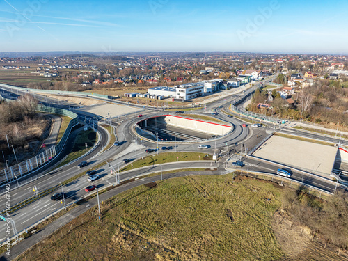 Krakow, Poland. Wegrzce interchange on new S52 highway (below) opened on December 23, 2024. Part of freeway around Cracow. Traffic circle with a hole inside and ramps. Aerial view in sunset light photo