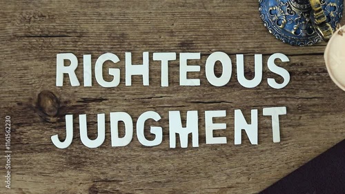 Righteous judgment wooden text on rustic background with ancient balance scale. Top view. Close-up. Biblical concept of Christian law, justice, and salvation by God Jesus Christ.