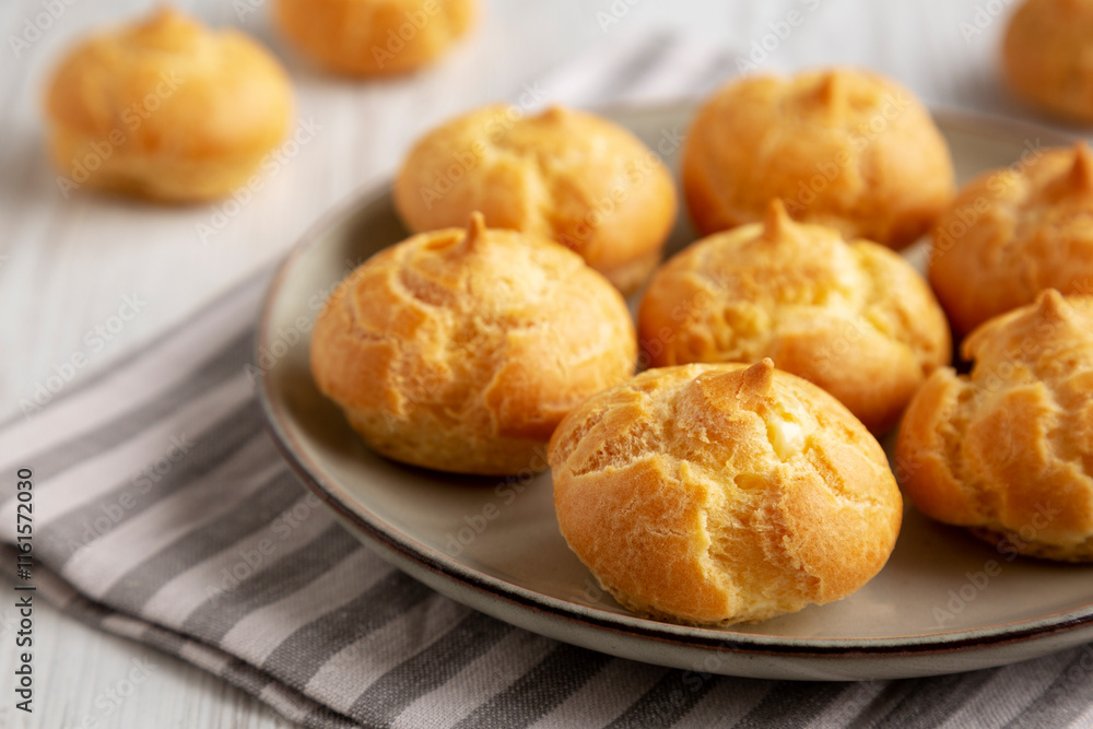 Homemade French Mini Cream Puffs on a Plate, side view. Homemade French Mini Cream Puffs on a Plate, side view.