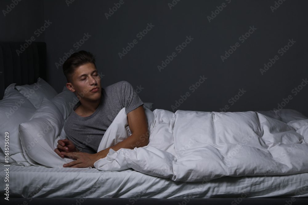 Young man suffering from sleepwalking on bed at home Young man suffering from sleepwalking on bed at home