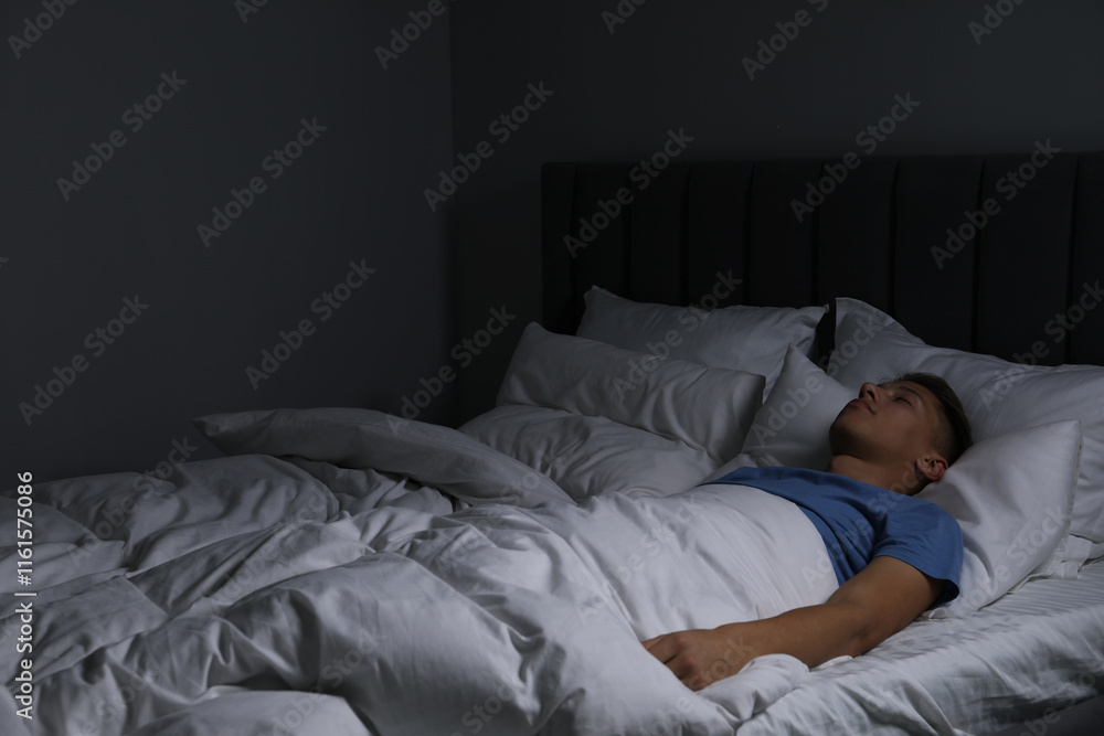Young man sleeping in soft bed at night Young man sleeping in soft bed at night