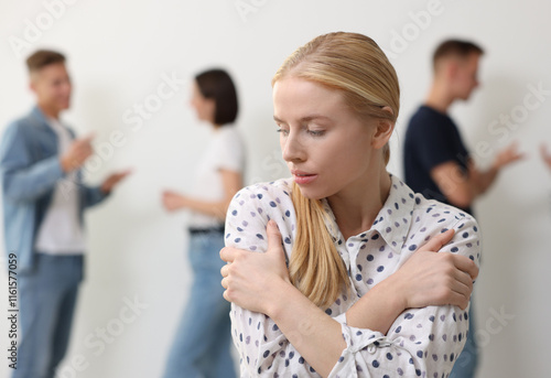 Bild auf Leinwand Young woman feeling uncomfortable among people indoors, selective focus