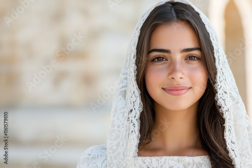 A radiant bride sporting a delicate lace veil flashes a charming smile, embodying elegance and happiness on one of the most memorable days of her life. photo