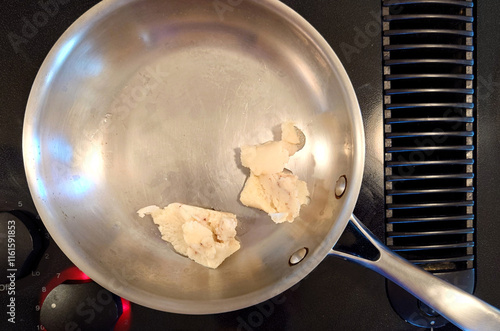 lumps of bacon grease in a stainless-steel skillet photo