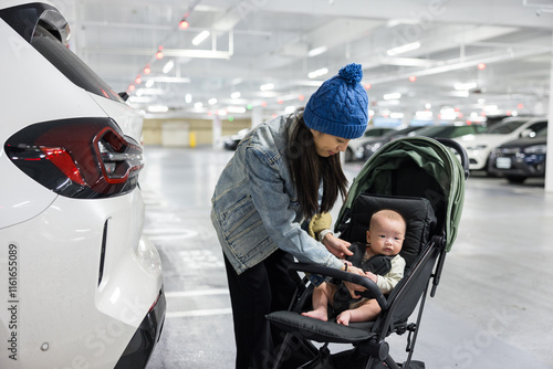 Mom put the baby on stroller at parking lot photo