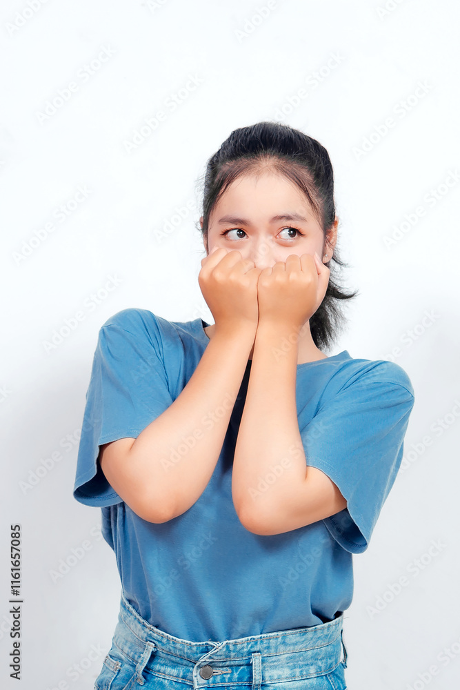 Scared Asian woman looking to the copy space upwards while covering her mouth. She is in a state of shock or disbelief. Scared Asian woman looking to the copy space upwards while covering her mouth. She is in a state of shock or disbelief.