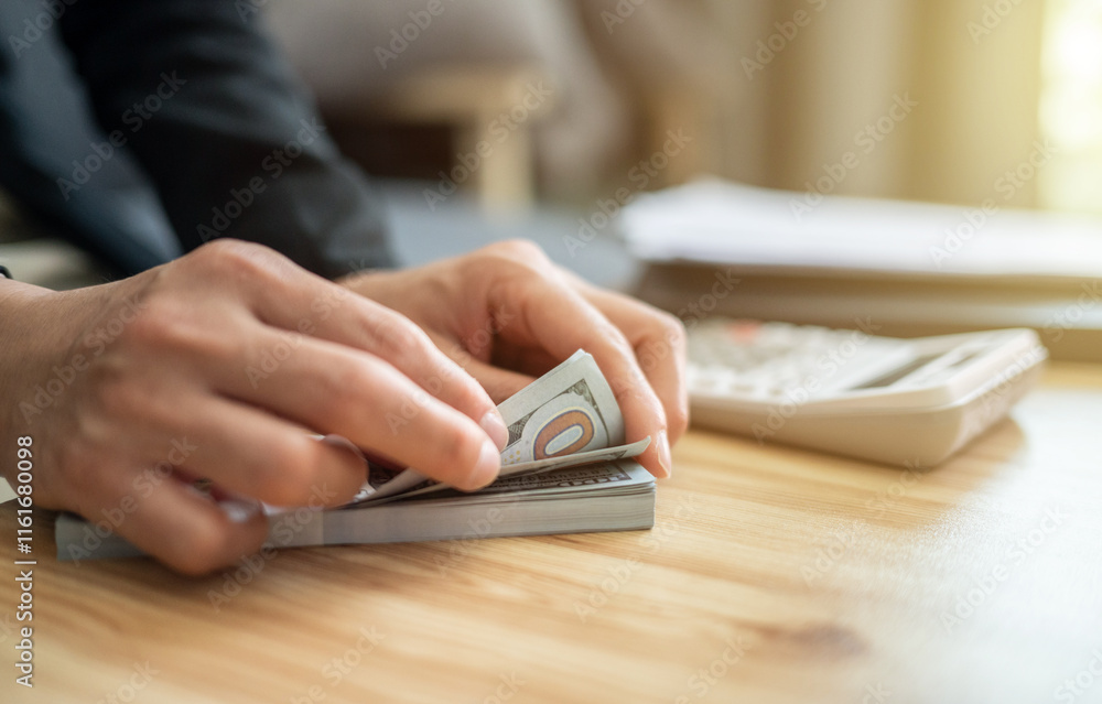 Cropped shot view of someone counting American dollar banknotes. The US Dollar is the currency of United States. Cropped shot view of someone counting American dollar banknotes. The US Dollar is the currency of United States.