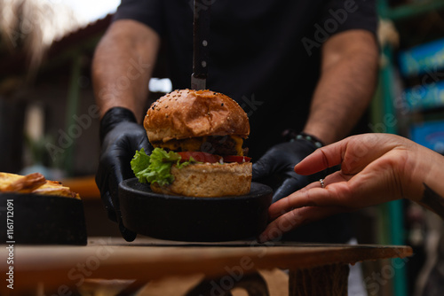 Chef Presenting a Delicious Burger to a Customer photo