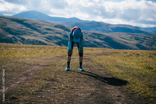 Tired woman trail runner running in grassland photo