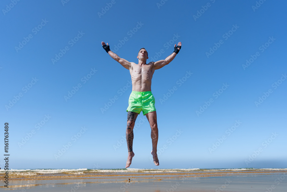 Hombre luchador de ckic boxing muy a gusto recargándose con la energía del sol, el mar y el contacto con la naturaleza un sensacional díe de verano en vacaciones soleado y con cielo azul. Hombre luchador de ckic boxing muy a gusto recargándose con la energía del sol, el mar y el contacto con la naturaleza un sensacional díe de verano en vacaciones soleado y con cielo azul.