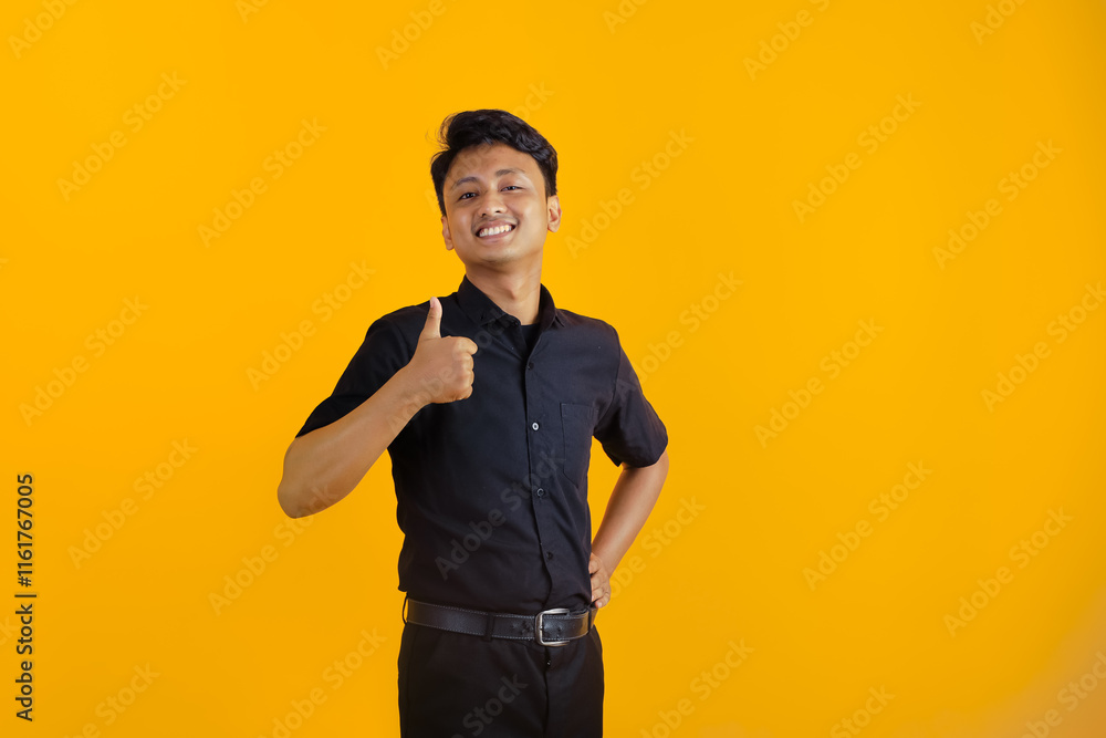 Portrait of an Asian Indonesian man, wearing a black shirt, posing OK with thumbs up, isolated on white background. Portrait of an Asian Indonesian man, wearing a black shirt, posing OK with thumbs up, isolated on white background.